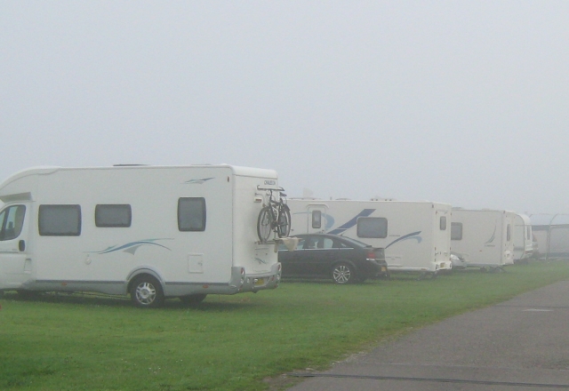 a row of caravans and capervans in the mist